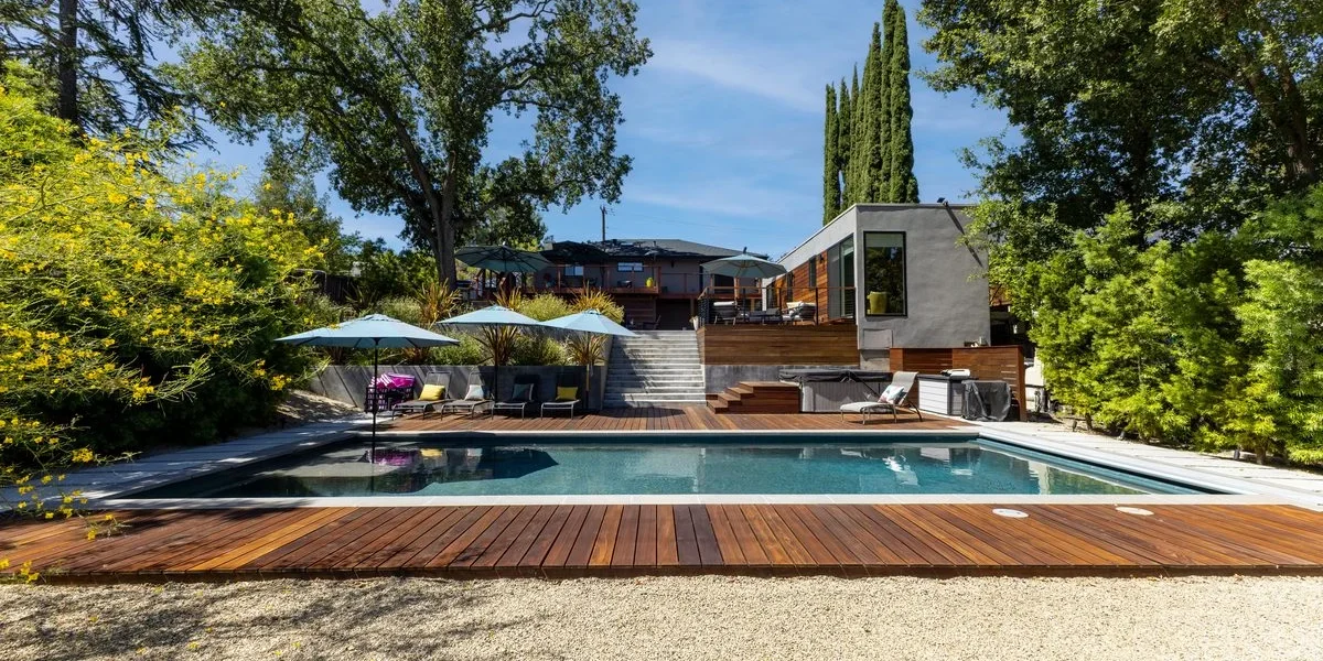 San Miguel custom pool with dark plaster finish and hardwood decking